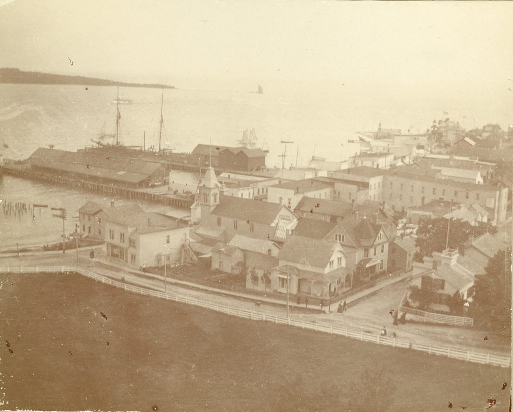 The New Mackinac Hotel can be seen at the right center of this 1899 view. This provides a good view of back wing, kitchen wing, ice house, and a water tank at the very rear of the building.